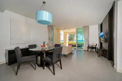 a dining room and living room with a table and chairs at Karon Beachfront Apartment 703 in Karon Beach