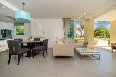 a kitchen and living room with a table and chairs at Karon Beachfront Apartment 703 in Karon Beach