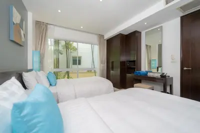a bedroom with two white beds and a window at Karon Beachfront Apartment 703 in Karon Beach
