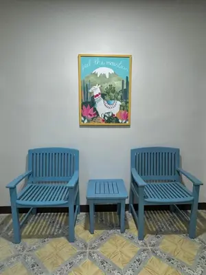 three blue benches sitting next to a painting on a wall at Cuckoo's Nest Ao Nang in Ban Khlong Son