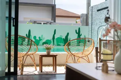 three chairs and a table with flowers on a patio at Stylish Pool Villa in Chalong-Phuket-2 Bedroom in Ban Suan