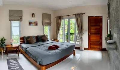 a bedroom with a large bed and a balcony at Picha house Kohyaonoi in Ban Laem Sai