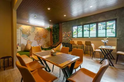 a restaurant with a table and chairs in a room at Mitsu Guesthouse in Karon Beach