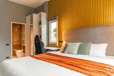 a bedroom with a bed with an orange wall at The Rich Villas House Pool Chalong Robinson in Ban Suan