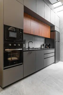 a kitchen with stainless steel appliances and wooden cabinets at The Rich Villas House Pool Chalong Robinson in Ban Suan