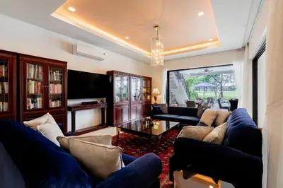 a living room with blue couches and a tv at Villa Viola 7 Bedroom, Fully Staffed, on the Golf Course in Laguna Phuket