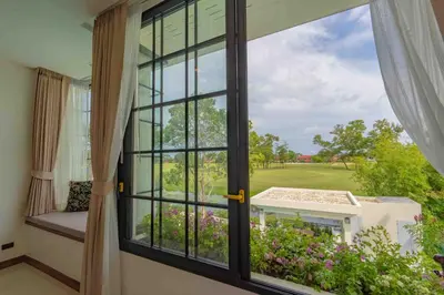 a window with a view of a golf course at Villa Viola 7 Bedroom, Fully Staffed, on the Golf Course in Laguna Phuket