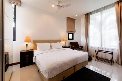 a bedroom with a large white bed and a window at Villa Viola 7 Bedroom, Fully Staffed, on the Golf Course in Laguna Phuket