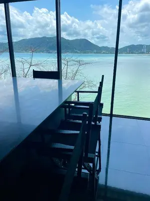 a table and chairs with a view of the water at Tri Trang Beachfront Apartments with Stunning Views in Patong Beach