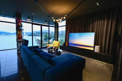 a living room with a blue couch and a flat screen tv at Tri Trang Beachfront Apartments with Stunning Views in Patong Beach