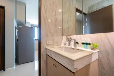 a bathroom with a sink and a refrigerator at Surin sea view 3br apartment with jacuzzi in Surin Beach