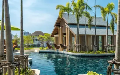a pool at a resort with palm trees at Surin sea view 3br apartment with jacuzzi in Surin Beach