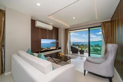 a living room with a white couch and a glass table at Surin sea view 3br apartment with jacuzzi in Surin Beach