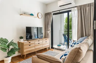 a living room with a couch and a tv at Title Halo Vitamin Sea 40m2 King Bed Naiyang in Nai Yang Beach