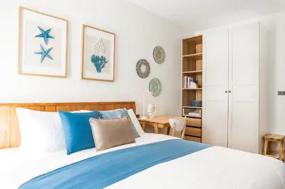 a bedroom with a bed with blue pillows at Title Halo Vitamin Sea 40m2 King Bed Naiyang in Nai Yang Beach