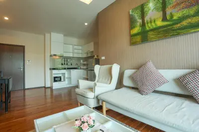 a living room with a white couch and two chairs at C251 Beachfront gym Sauna 7 Swimming Pool in Rawai Beach