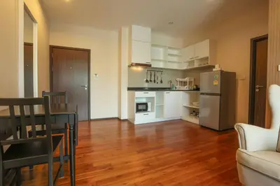 a kitchen and living room with a table and a refrigerator at C251 Beachfront gym Sauna 7 Swimming Pool in Rawai Beach