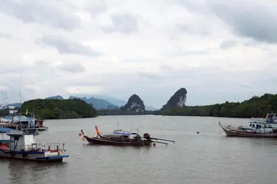 three boats in the water with mountains in the background at The Capuchin Hotel Krabi, Ao Nang Beach in Ao Nang Beach