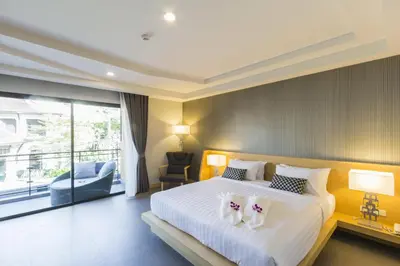 a bedroom with a large bed with two shoes on it at The Capuchin Hotel Krabi, Ao Nang Beach in Ao Nang Beach