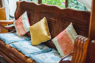 a couch with four pillows sitting on it at RK Guesthouse in Patong Beach