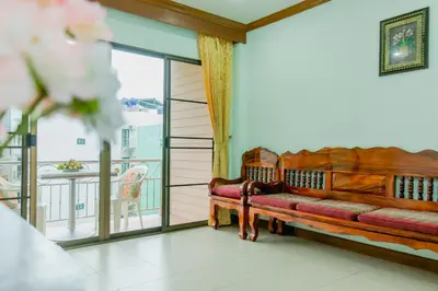 a couch in a room with a balcony at RK Guesthouse in Patong Beach