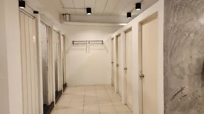 an empty corridor with white walls and a hallway with doors at iRest Ao Nang Hostel in Ao Nang Beach