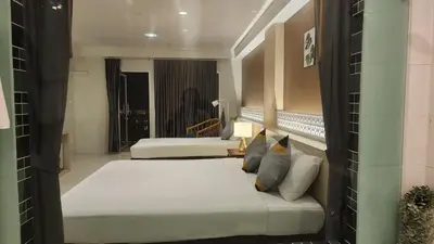 a hotel room with two beds and a window at iRest Ao Nang Hostel in Ao Nang Beach