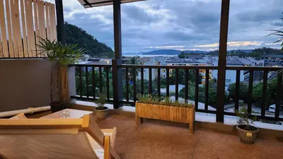 a balcony with a bench and a view of a city at iRest Ao Nang Hostel in Ao Nang Beach