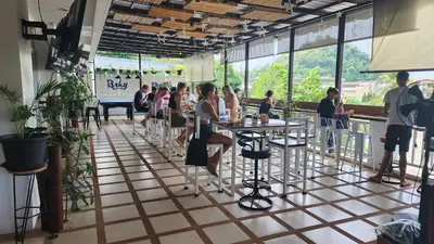 a group of people sitting at tables in a restaurant at iRest Ao Nang Hostel in Ao Nang Beach