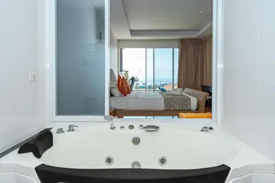 a bathroom with a bath tub with a large mirror at Hillside Seaview Residence in Karon Beach