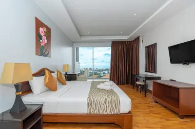 a hotel room with a bed and a desk and a television at Hillside Seaview Residence in Karon Beach