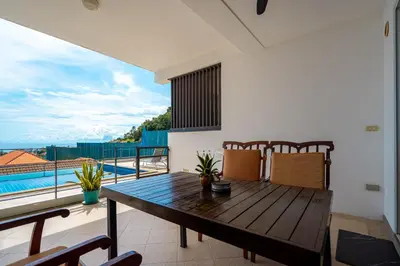 a dining room with a table and a view of a pool at Hillside Seaview Residence in Karon Beach