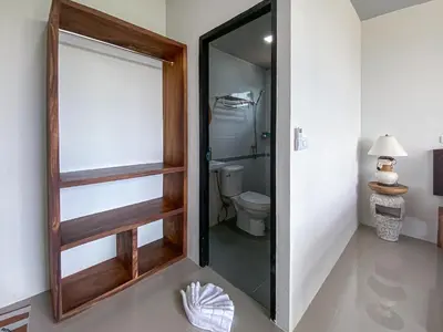 a bathroom with a toilet and a glass door at Samet Nangshe Goodview in Ban Met Nang Chi
