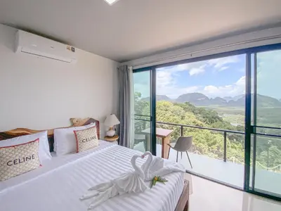a bedroom with a bed and a large window at Samet Nangshe Goodview in Ban Met Nang Chi