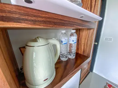 a blender and two bottles of water in a cupboard at Samet Nangshe Goodview in Ban Met Nang Chi