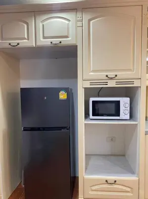 a kitchen with a black refrigerator and white cabinets at Kata#near macro karon # 1km to kata beach in Karon Beach
