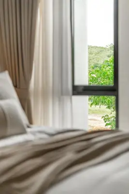 a close up of a bed with a window at Title Halo Timeless Naiyang Pool Gym Sauna in Nai Yang Beach