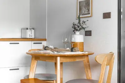 a kitchen with a wooden table with two chairs at Title Halo Timeless Naiyang Pool Gym Sauna in Nai Yang Beach