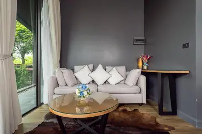 a living room with a couch and a table at Spacious Pool Access Apartment with 2 BR - Rawai in Ban Saiyuan (1)