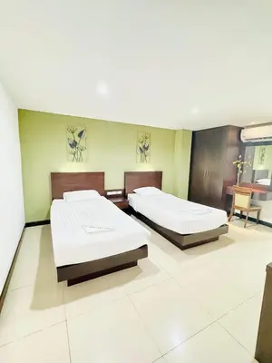 two beds in a large room with at La Casa Patong in Patong Beach