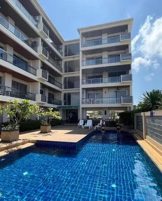 a swimming pool in front of a building at Rawai apartments in Ban Saiyuan (1)