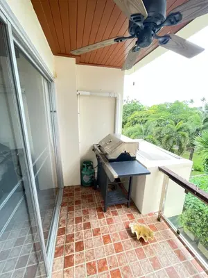 a porch with a table and a ceiling fan at Rawai apartments in Ban Saiyuan (1)