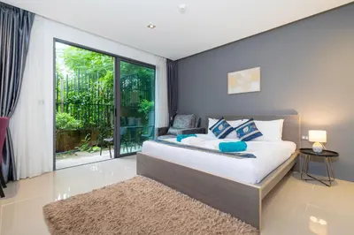 a bedroom with a bed and a large window at Studio Apartment - Emerald Terrace Patong in Patong Beach