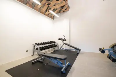 a room with a gym with a bench and weights at Studio Apartment - Emerald Terrace Patong in Patong Beach