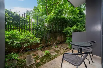 a patio with a table and a chair and a fence at Studio Apartment - Emerald Terrace Patong in Patong Beach