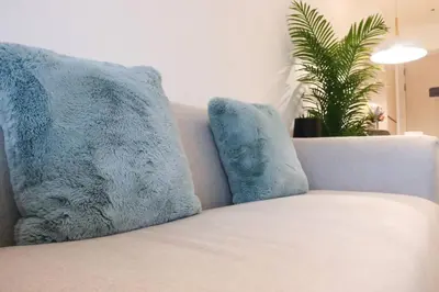 a couch with two pillows and a plant on it at Cassia Residences Sea View in Laguna Phuket