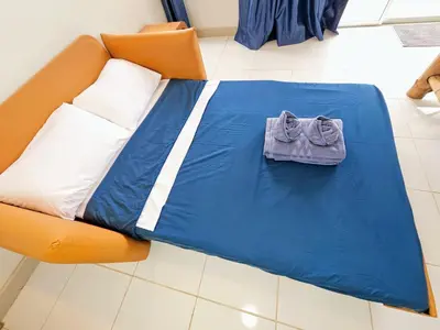 a bed with a blue sheet on it at Beach Front Queen's Castle - Kid friendly, Holiday like Royalty in Ban Ao Makham