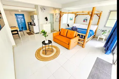 a bedroom with a bed and a couch and a table at Beach Front Queen's Castle - Kid friendly, Holiday like Royalty in Ban Ao Makham