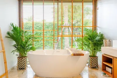 a bathroom with a large tub in front of a window at Stylish Pool Villa Tropical Hideaway in Ban Phru Champa