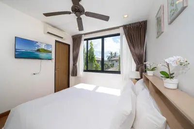 a bedroom with a white bed and a window at Laguna pool house in Phuket Town